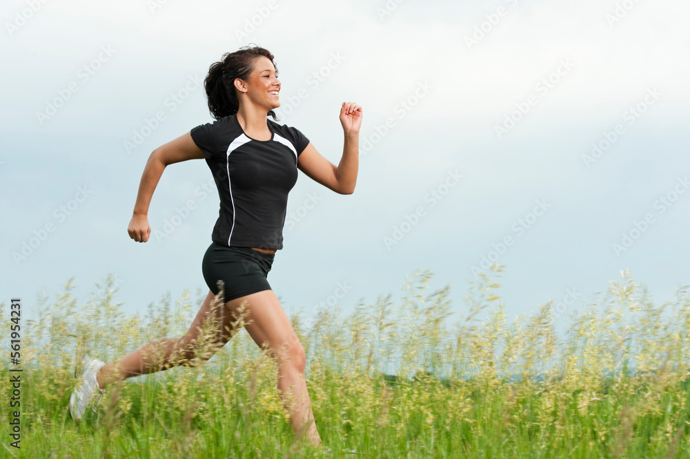Young woman running on grass trail through a bright green field at Spirit Mound, South Dakota. Young woman running on grass trail through a bright green field at Spirit Mound, South Dakota.