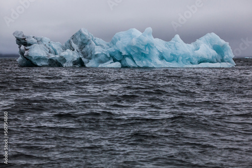 Portrait of a calved iceberg floating in choppy water in Hornsund, Svalbard. photo
