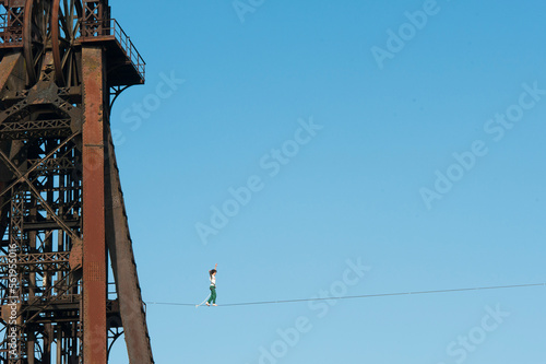 Highliner balancing on tightrope on mine shaft tower, Charleroi, Wallonia, Belgium photo
