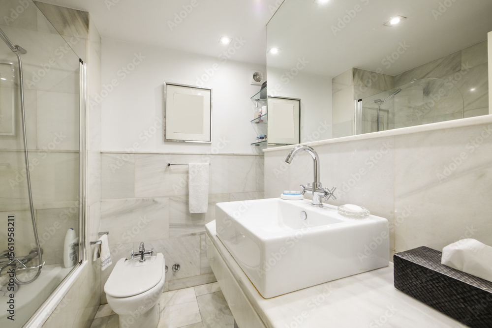 Beautiful bathroom with white marble tiles with a mirror integrated into the wall, an educational cabin with a glass partition and porcelain toilets Beautiful bathroom with white marble tiles with a mirror integrated into the wall, an educational cabin with a glass partition and porcelain toilets