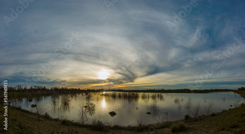 Sunset reflecting on flooded land next to levee