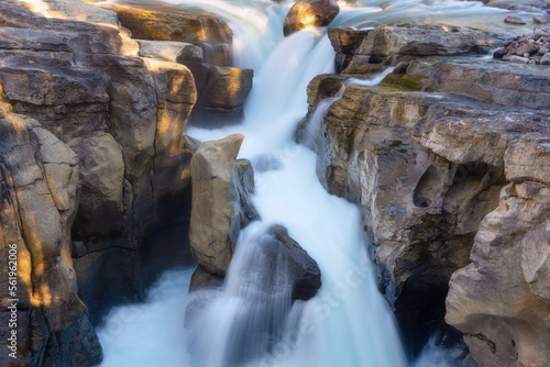 Waterfall and rocks. Long exposure photography. Fast river and waterfall. Natural background and wallpaper. Blurry fast water.