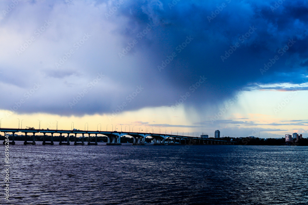 A tornado crossing a bridge over a body of water