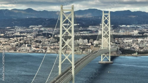 Aerial Rotation Over Light Traffic on Suspension Bridge to Coastal City