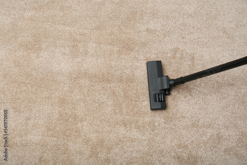 Removing dirt from carpet with modern vacuum cleaner indoors, top view. Space for text