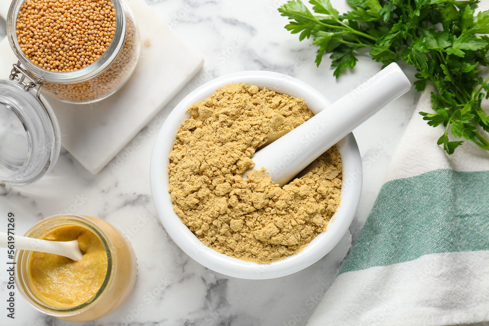 Flat lay composition with mortar and aromatic mustard powder on white marble table Flat lay composition with mortar and aromatic mustard powder on white marble table