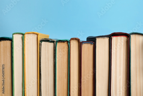 Many old books on light blue background, closeup