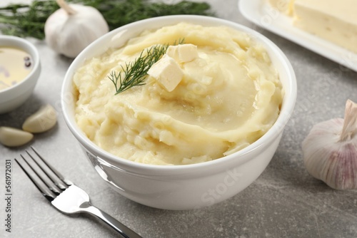 Delicious mashed potato with dill served on light grey table