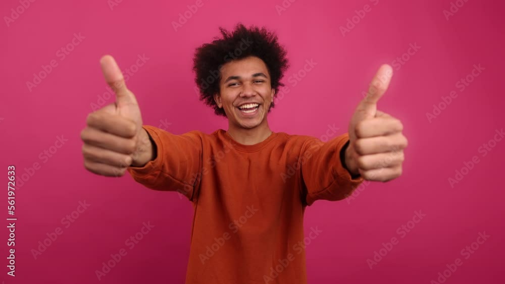 Close-up shot of cute student making a supportive gesture. Portrait of cool, trendy man in his 20s smiling while showing thumbs up. High quality 4k footage Close-up shot of cute student making a supportive gesture. Portrait of cool, trendy man in his 20s smiling while showing thumbs up. High quality 4k footage