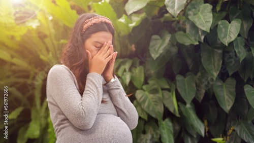 Sad and stressed Asian pregnant woman.
 Pregnant woman hold forehead. healthy and sickness concept.