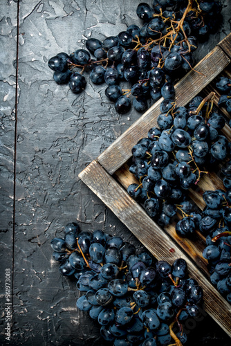 Black grapes on a wooden tray.