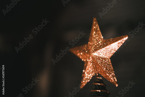a star ornament on top of a small christmas tree