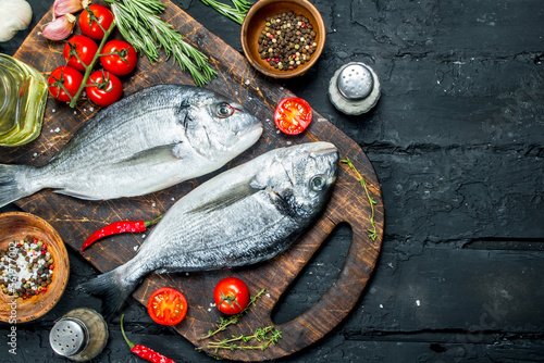 Foto Raw sea fish dorado with spices and rosemary.