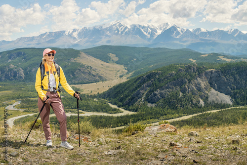 Happy woman traveler hiking with backpack at rocky mountains landscape. Travel Lifestyle active freedom concept. Hiking