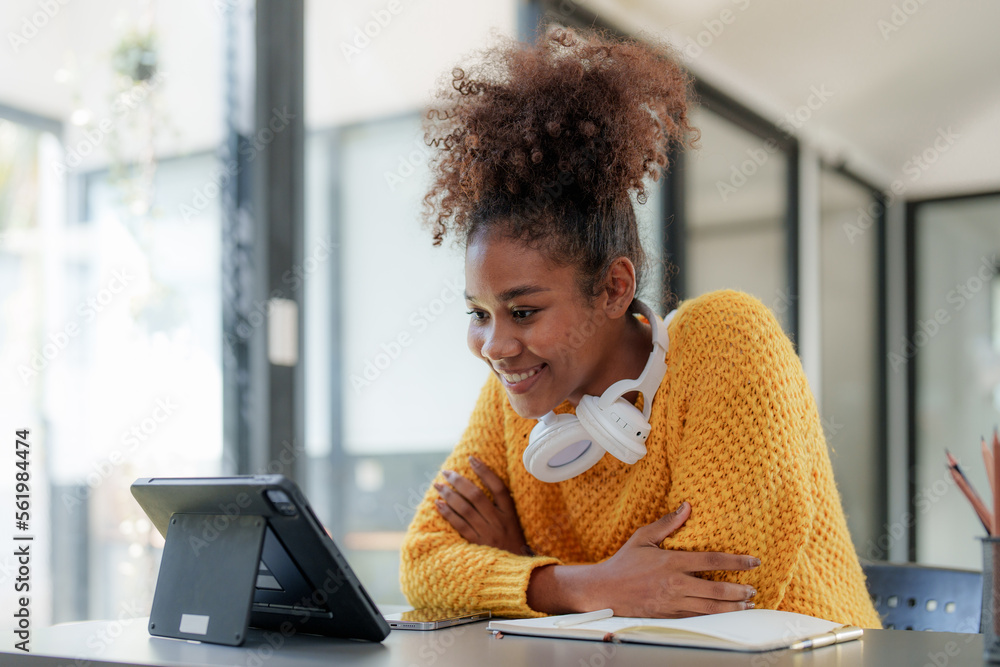 Young black curly hair American African woman using digital tablet Young black curly hair American African woman using digital tablet