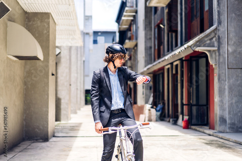 Portrait of hipster handsome businessman in suit with backpack looking forward while commuting riding bicycle on the street city way go to work.business travel transport bike concept.
