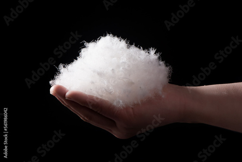 white down feathers hold in hand on black background