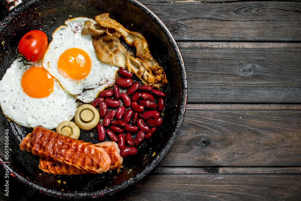 Traditional English Breakfast with fried eggs, sausages and beans.