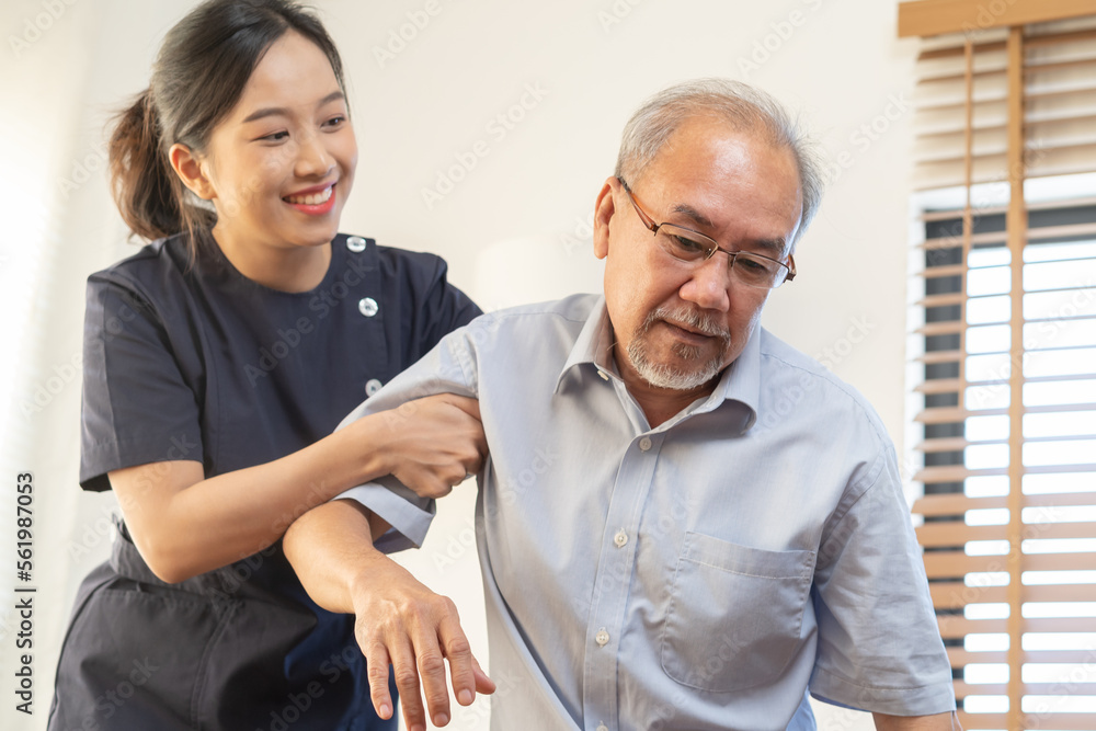 Obraz premium Mature man suffering from bone backache or stiff muscles, young caregiver care supporting elderly, aged pain, cure of grandmother after retirement, help support. Unhealthy posture or uncomfortable