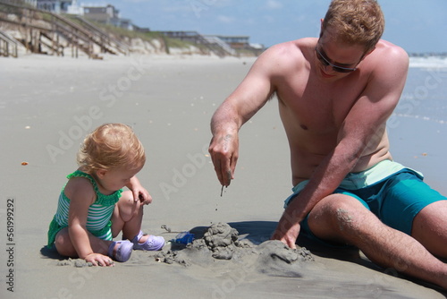 man and baby play in sand at Myrtle Beach South Carolina photo