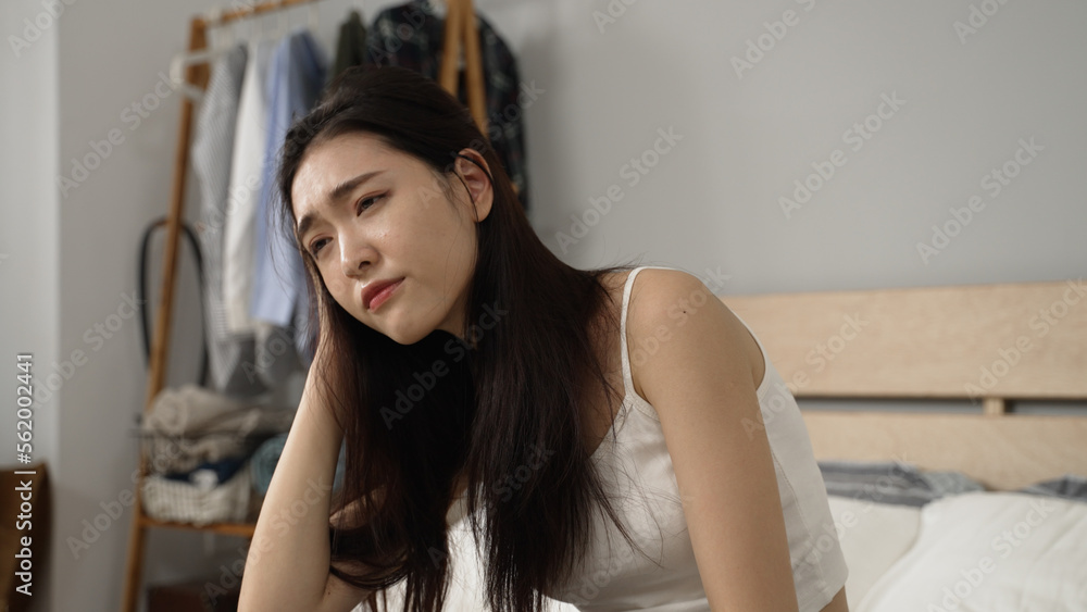 asian Korean girl feeling discomfort while massaging herself trying to ease pain in the head caused by hangover after awaking in the morning at home asian Korean girl feeling discomfort while massaging herself trying to ease pain in the head caused by hangover after awaking in the morning at home