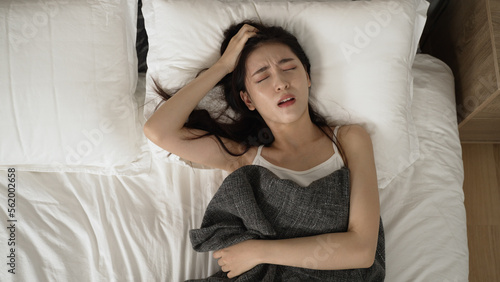 Fotografie above view of a restless asian japanese woman turning and tossing in agony on be