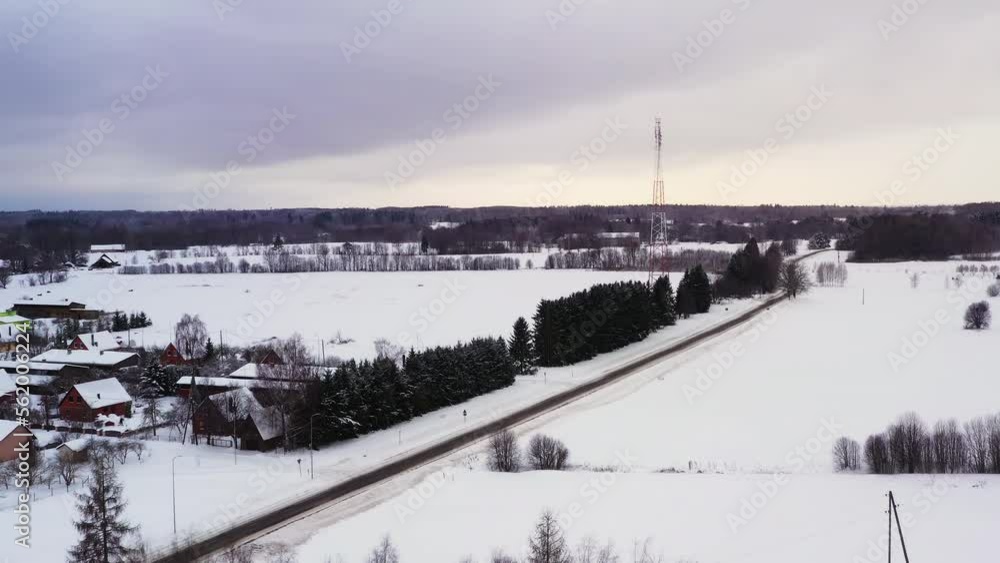 Telecommunication tower in small snow covered village on overcast winter day, aerial view Telecommunication tower in small snow covered village on overcast winter day, aerial view