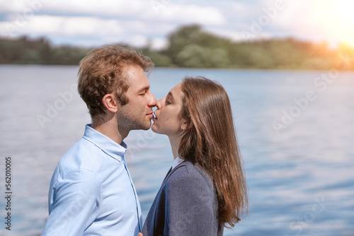 couple in love kissing standing on the shore of the lake .