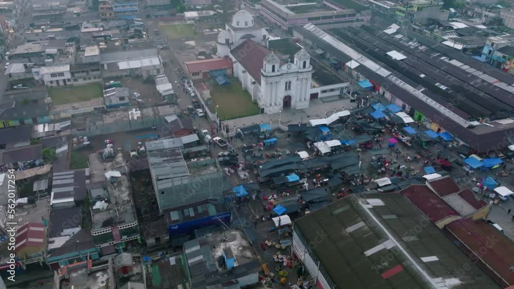 Wide slow aerial flyover around the central square in San Juan Ostuncalco, showing the market and the cathedral in the background. Wide slow aerial flyover around the central square in San Juan Ostuncalco, showing the market and the cathedral in the background.