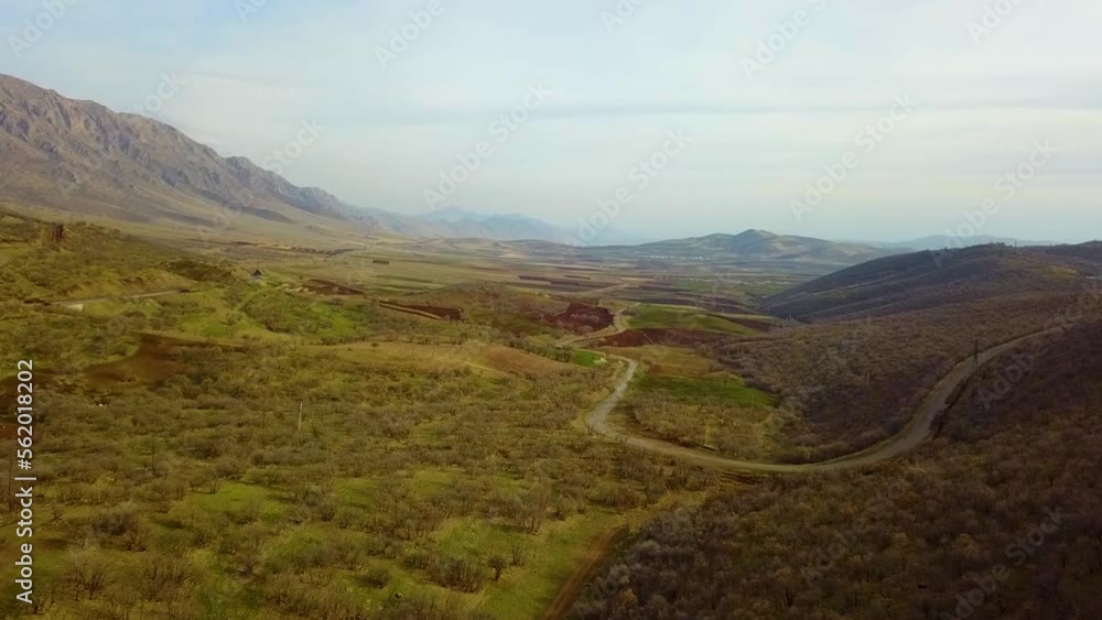 Drone shot over scenic landscape of mountain wild nature plain dry climate and local road for nomad people who live in traditional tent lifestyle is sustainable friend with wildlife support food bread Drone shot over scenic landscape of mountain wild nature plain dry climate and local road for nomad people who live in traditional tent lifestyle is sustainable friend with wildlife support food bread