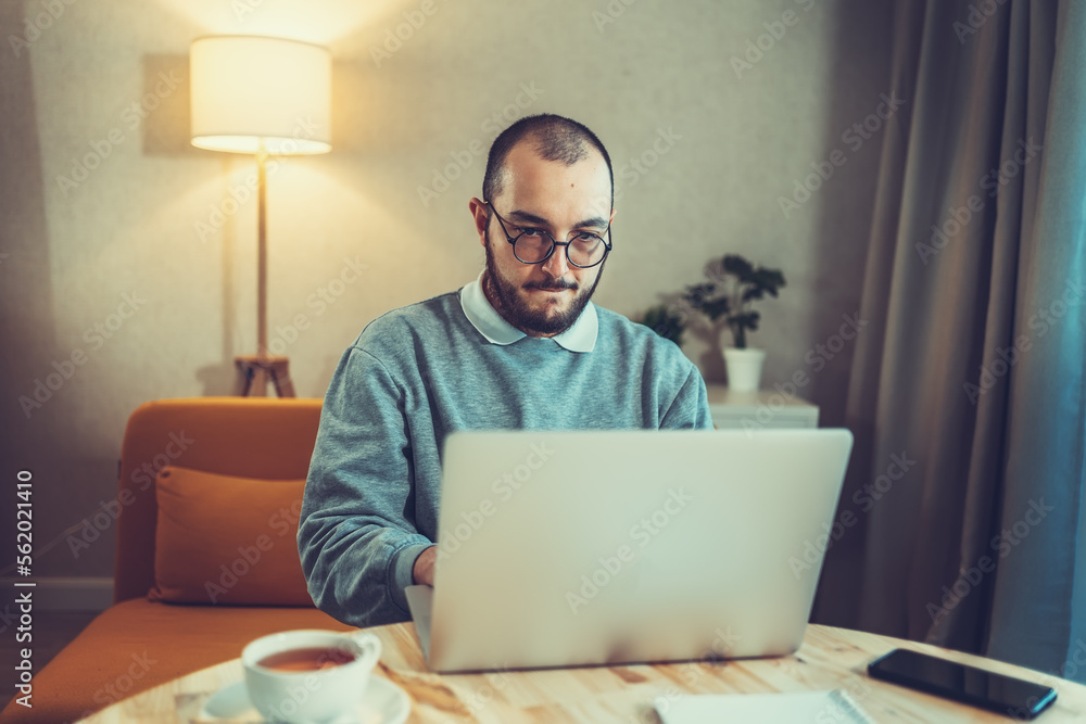 Male freelancer or IT code developer working at laptop. Programmer or young businessman at home office, distant job. Male freelancer or IT code developer working at laptop. Programmer or young businessman at home office, distant job.