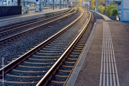 Empty platform with S-Bahn train line S6 destination Baden arriving at railway station Zürich Oerlikon in backlight on a sunny autumn evening. Photo taken November 26th, 2022, Zurich, Switzerland.