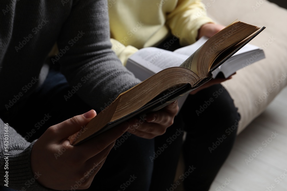 Couple sitting and reading holy Bibles, closeup