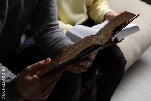 Couple sitting and reading holy Bibles, closeup