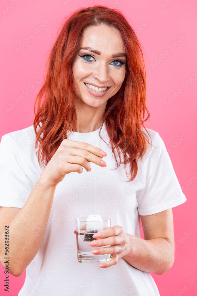 Winsome Caucasian Happy woman Making Tea on Cup Using Teabag Isolated Over Pink Winsome Caucasian Happy woman Making Tea on Cup Using Teabag Isolated Over Pink