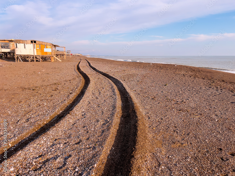 Wheel track of a 4x4 vehicle driving past the beach at sunset