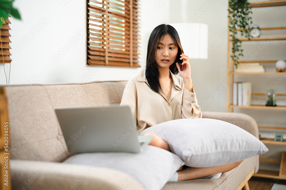 Asian girl using cell phone for checking social media at home holding smartphone in morning. Asian girl using cell phone for checking social media at home holding smartphone in morning.