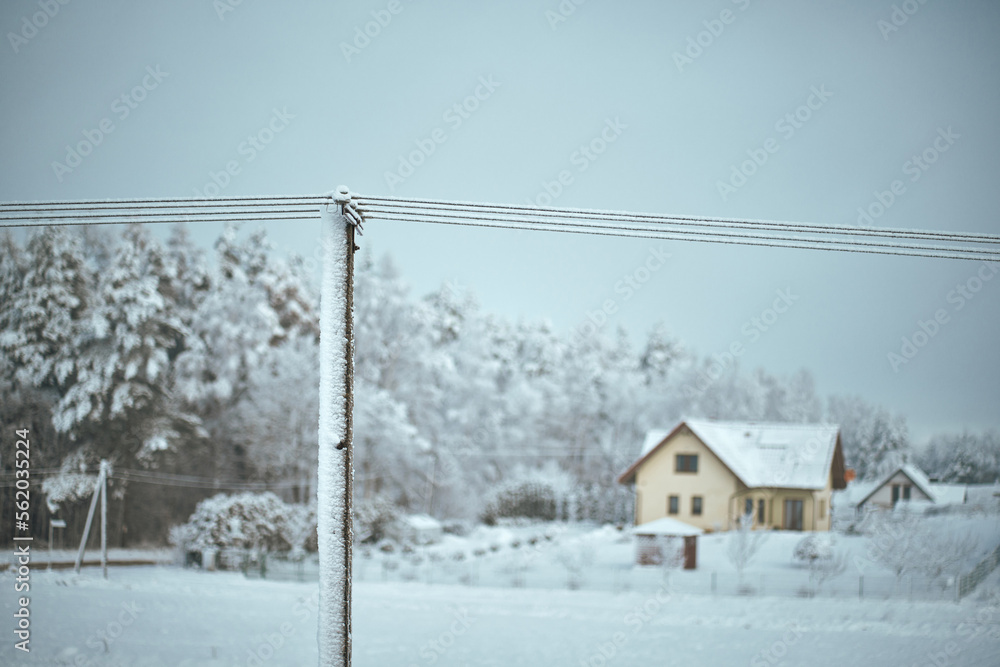 A utility pole and wires are covered with ice. Power outage during a winter snowstorm. A utility pole and wires are covered with ice. Power outage during a winter snowstorm.