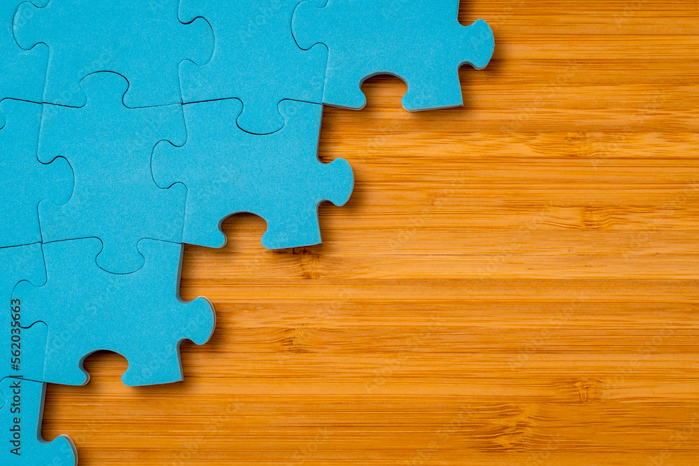 Blue puzzle on wooden background with a copy space Blue puzzle on wooden background with a copy space