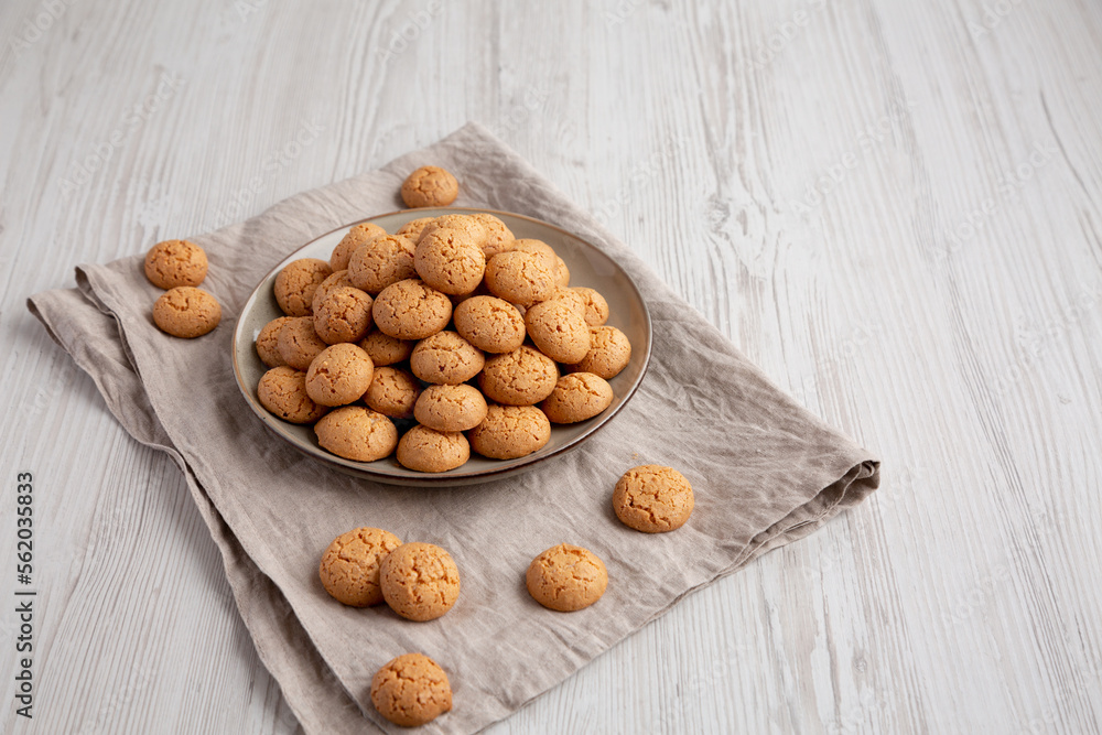 Homemade Italian Amaretti Cookie Biscuits on a Plate, side view. Space for text. Homemade Italian Amaretti Cookie Biscuits on a Plate, side view. Space for text.