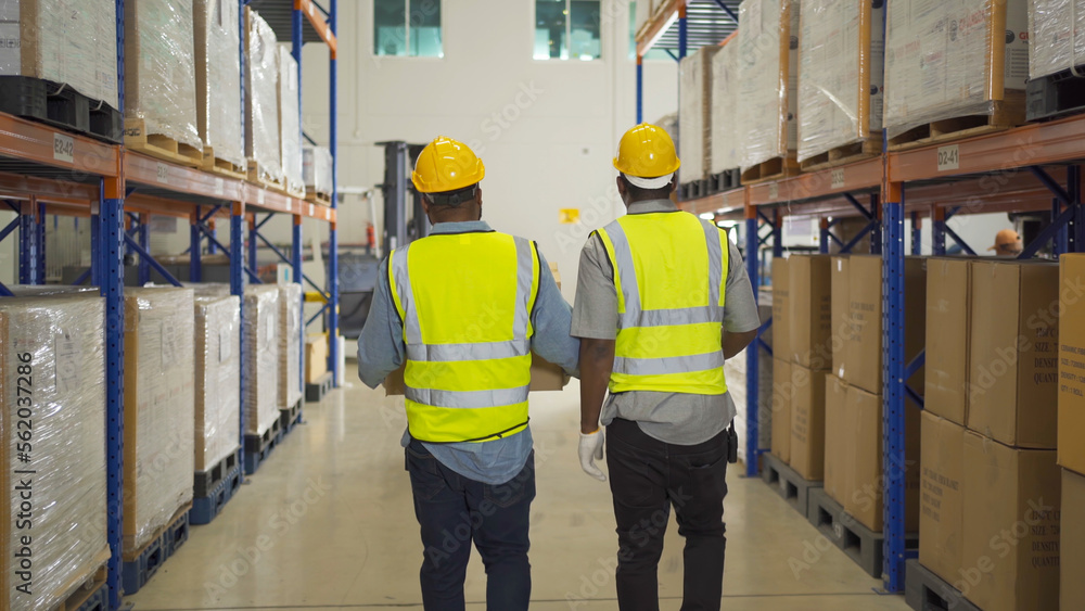 Teamwork of black workers working in large warehouse store industry.Rack of stock storage. Interior of cargo in ecommerce and logistic concept. Depot. People lifestyle. Shipment service for container Teamwork of black workers working in large warehouse store industry.Rack of stock storage. Interior of cargo in ecommerce and logistic concept. Depot. People lifestyle. Shipment service for container