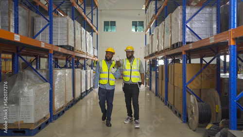 Teamwork of black workers working in large warehouse store industry.Rack of stock storage. Interior of cargo in ecommerce and logistic concept. Depot. People lifestyle. Shipment service for container