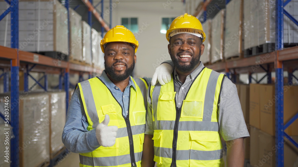 Teamwork of black workers working in large warehouse store industry.Rack of stock storage. Interior of cargo in ecommerce and logistic concept. Depot. People lifestyle. Shipment service for container