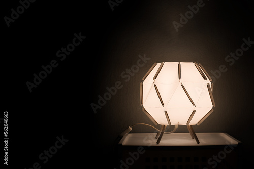 Lamps in bedroom decor with warm and glowing lights and black background.