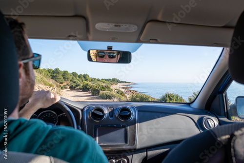 View of a blurred man driving a car on a dirt road through wild Mediterranean coast.