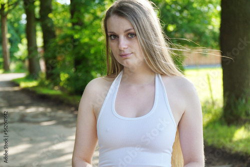 Beautiful young woman wearing white neckholder top outdoor in nature