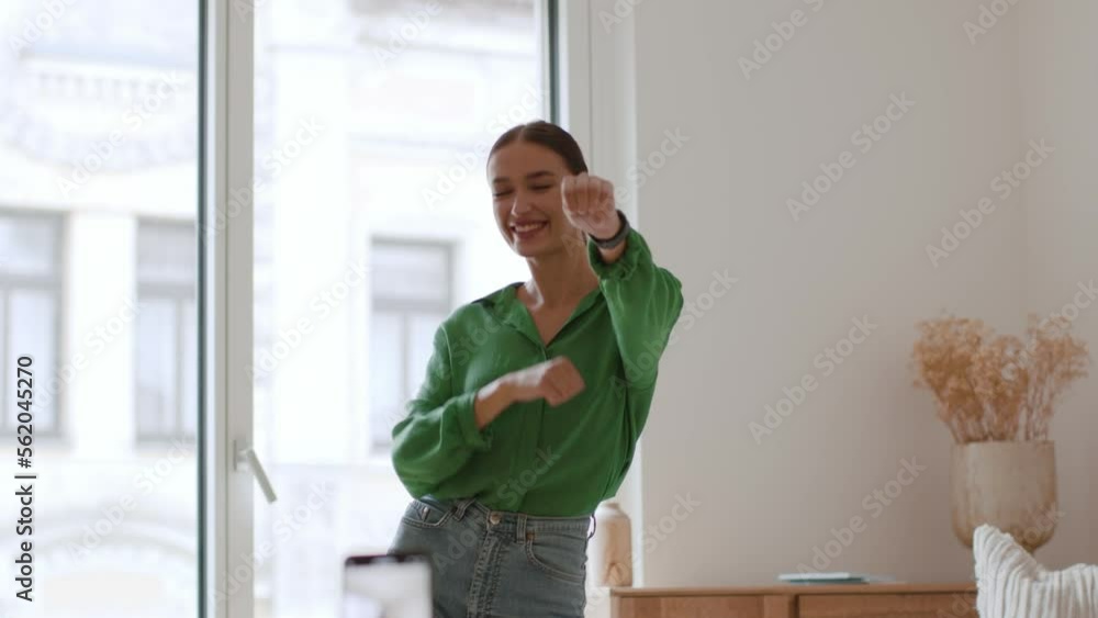 Modern social media trends. Young positive millennial woman dancing at home, recording funny video content on smartphone Modern social media trends. Young positive millennial woman dancing at home, recording funny video content on smartphone