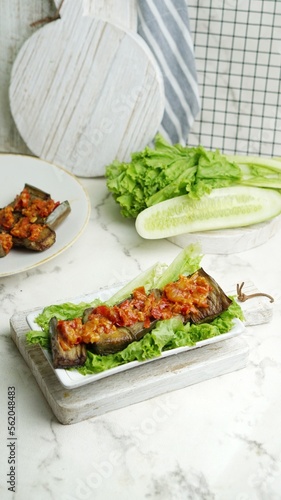 Terong Balado or eggplant with sambal balado on white background. Table setting