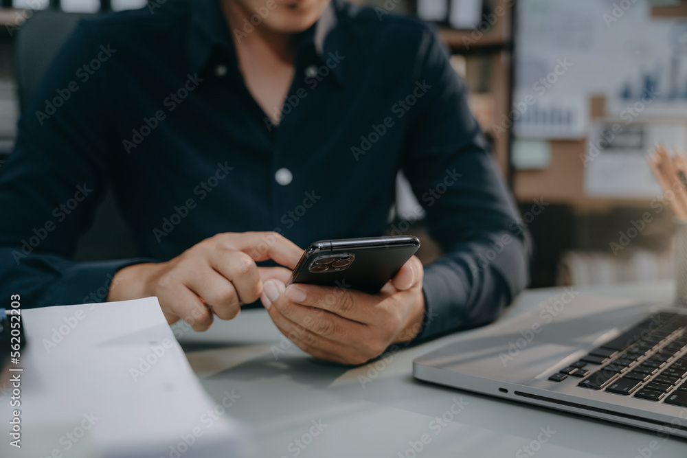 Male use their phones and computers to work in the morning.