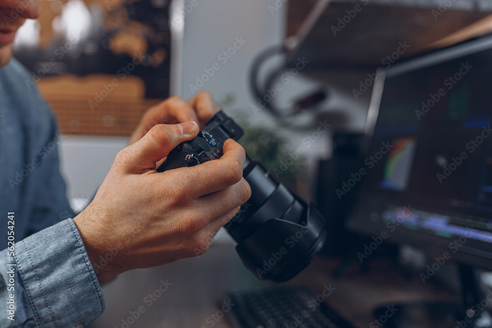 Crop man with professional photo camera in hands in home office Crop man with professional photo camera in hands in home office